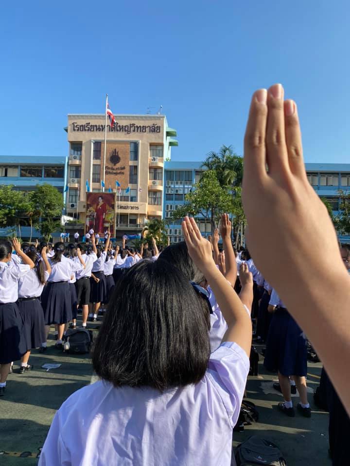 ภาพชูสามนิ้วของกลุ่มนักเรียนมัธยม