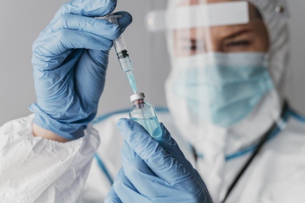 doctor holding preparing vaccine while wearing protective equipment 23 2148847188 HATYAITODAY