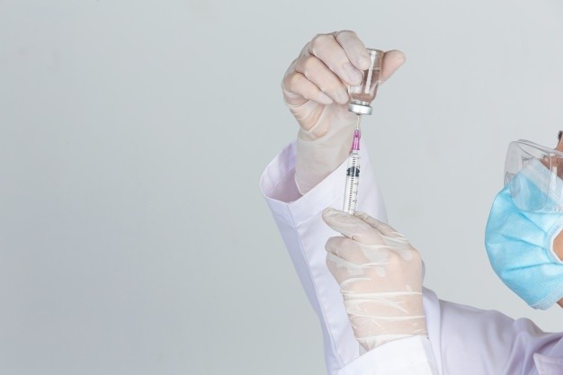Young Doctor Is Holding Hypodermic Syringe With Vaccine Vial Rubber Gloves Gray Wall 1150 21810