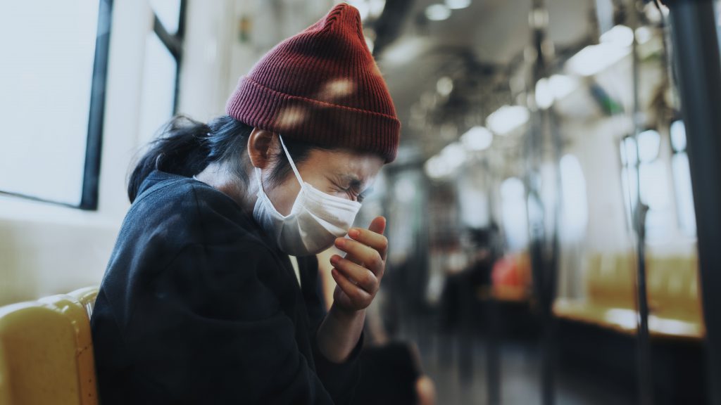 Sick Woman In A Mask Sneezing In A Train During Coronavirus Pandemic